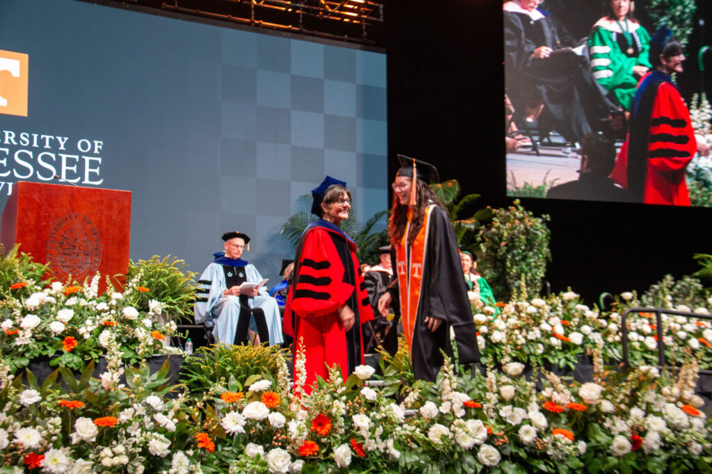 Master's student shakes the hand of the dean of the College of Education, Health and Human Sciences, Ellen McIntyre.