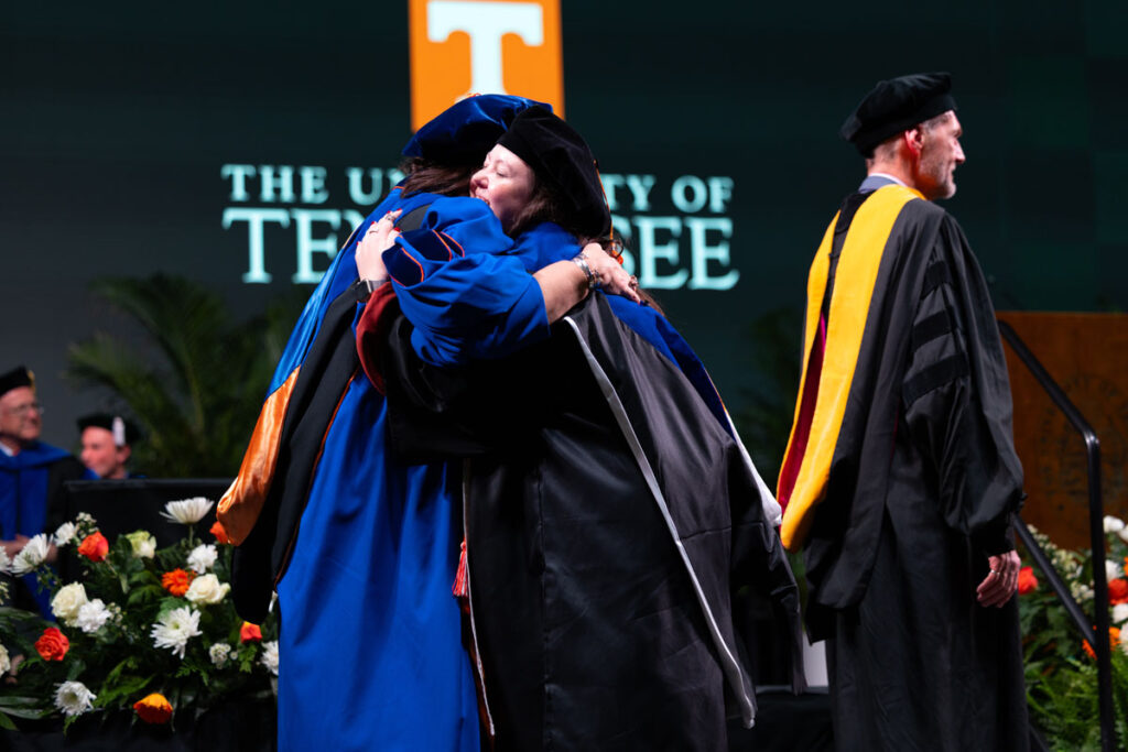 Vice Provost and Dean of the Graduate School Van Puymbroeck hugging a newly hooded doctor.