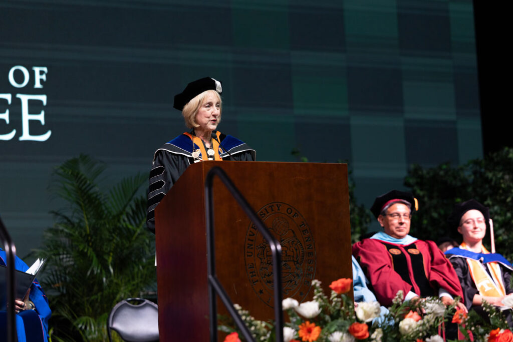 Chancellor Plowman at the podium conferring the degrees.
